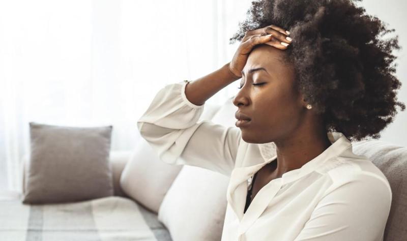 woman on couch with headache