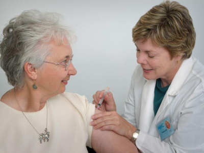 Nurse vaccinating older woman