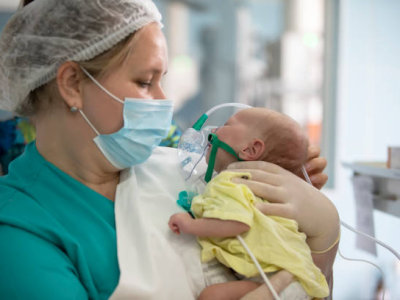 Nurse holding baby in hospital