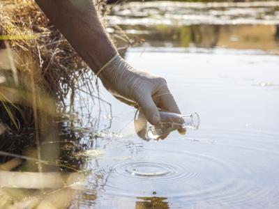 Gloved hand taking water sample