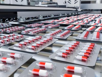 Red and white capsules in blister packs on production line