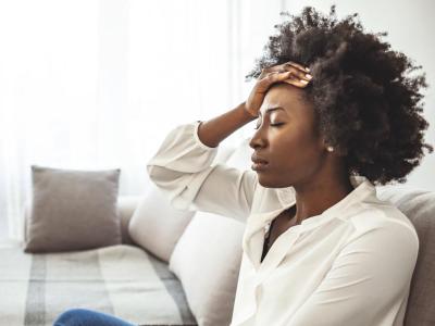 woman on couch with headache