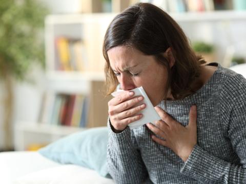 Coughing woman on couch