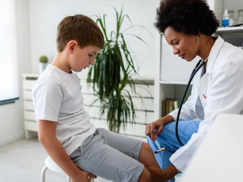 Doctor testing child's reflexes