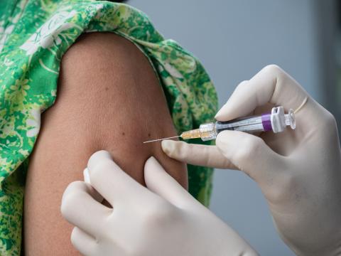 Girl in green dress being vaccinated