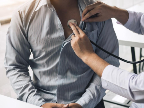 Doctor checking man's heart