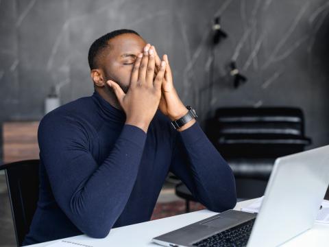 Man with headache at laptop