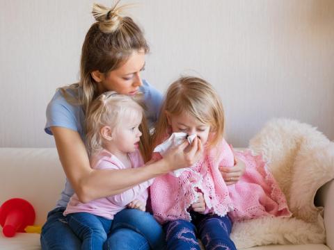 Mom with sick girl on couch