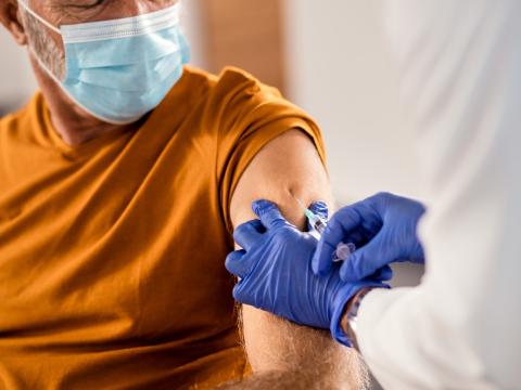 Older man getting vaccine in arm