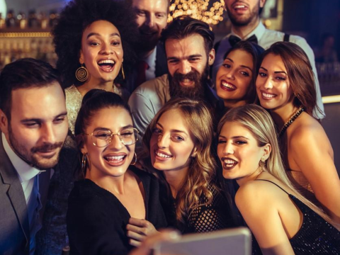 Young people posting for selfie in bar