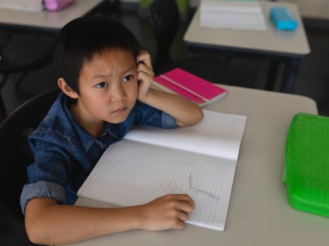 Puzzled young student at desk