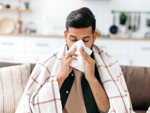 Sick guy blowing nose