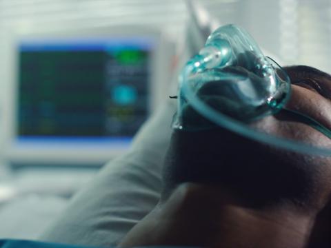 Supine patient wearing oxygen mask
