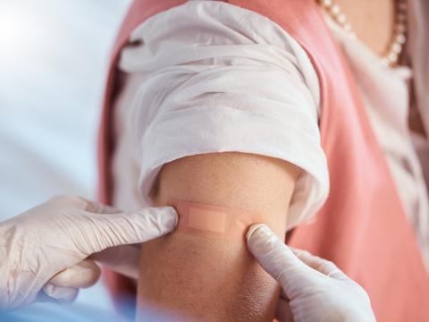 COVID vaccination in woman wearing pearls