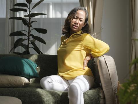 Woman with back pain on couch