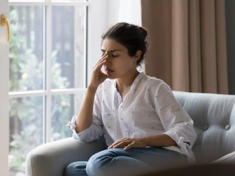 Young woman on couch with headache
