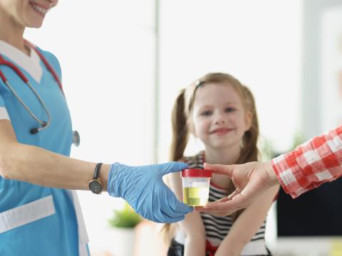Mother and child with doctor and urine sample