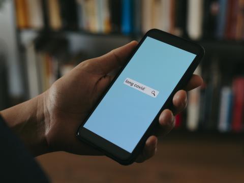 Person looking up long COVID on phone