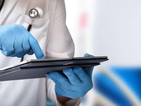 Man in hospital and doctor looking at tablet