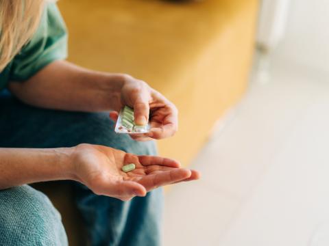Person with pill in hand