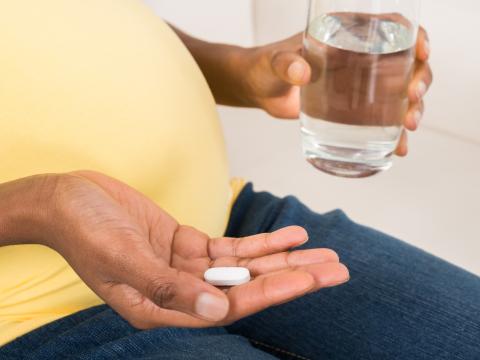 Pregnant women holding a pill