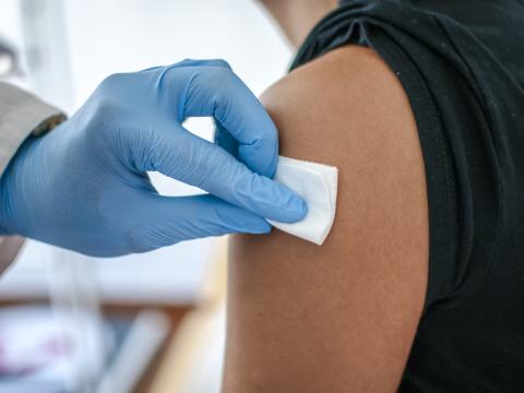 Doctor preparing arm for vaccination
