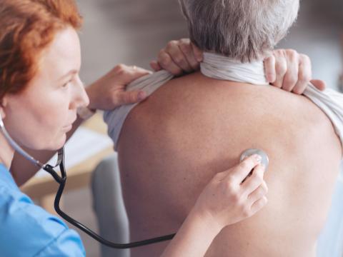 Doctor listening to patient breathing with stethoscope