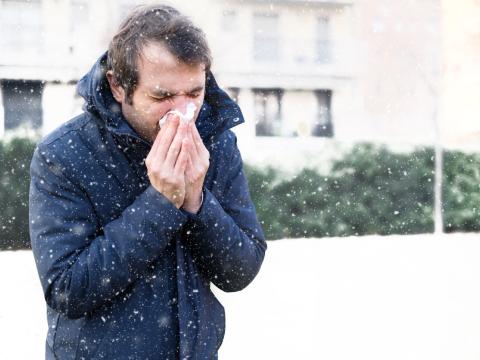 man sneezing outside