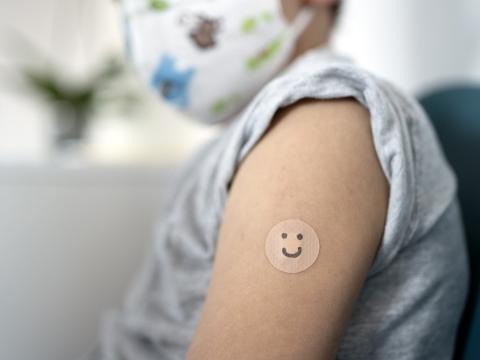 5-year-old boy with smiley-faced vaccine bandage