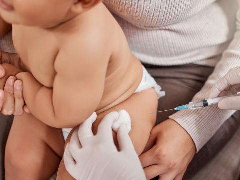 Baby getting vaccinated on mom's lap