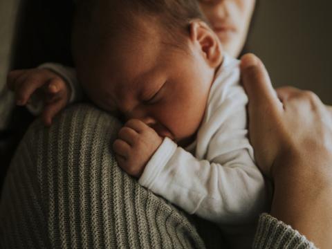 Baby snuggling on mom's shoulder