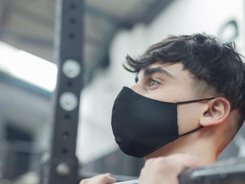 Boy wearing mask lifting weights