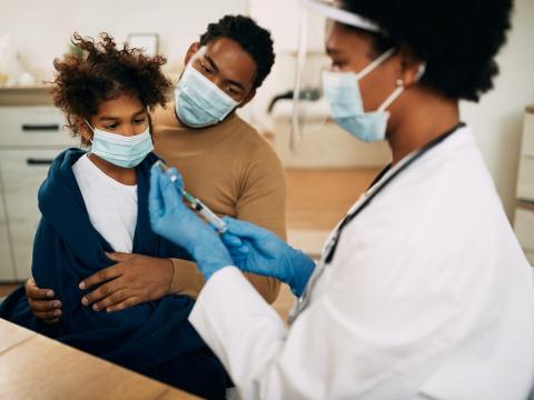 Child getting vaccinated with dad