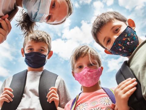 Circle of children wearing masks