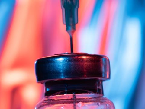 Close-up of needle inserted into vial