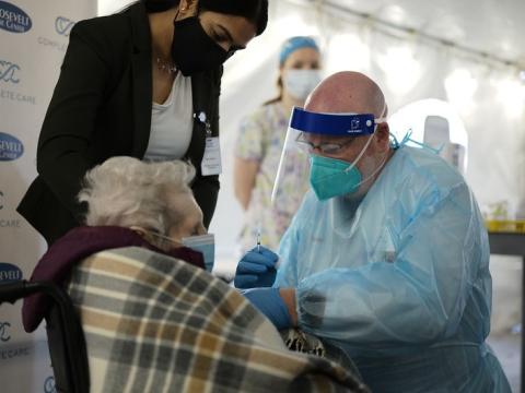 Elderly woman receiving COVID vaccine