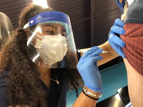 COVID vaccine needle going into arm