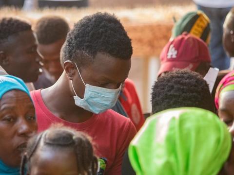 Crowd in Mali, one man wearing mask