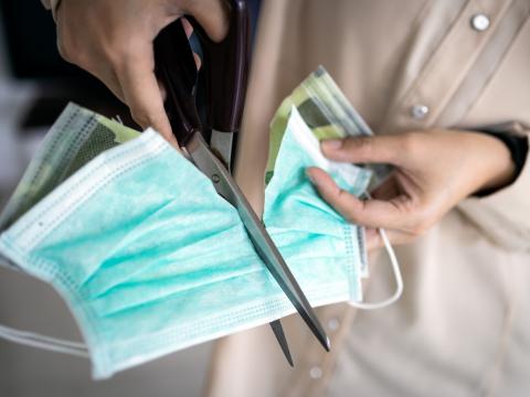 Woman cutting mask in two