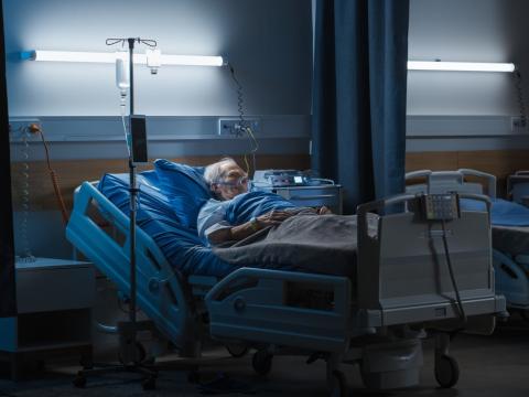 Elderly man in dark hospital room
