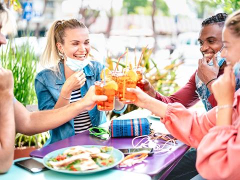 Friends drinking with masks down