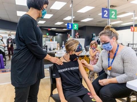 Girls getting vaccinated with mom
