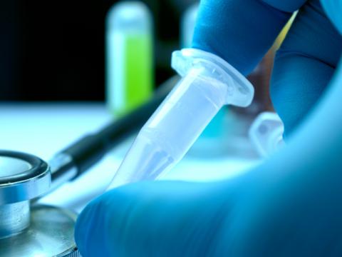 Gloved hand and research vial