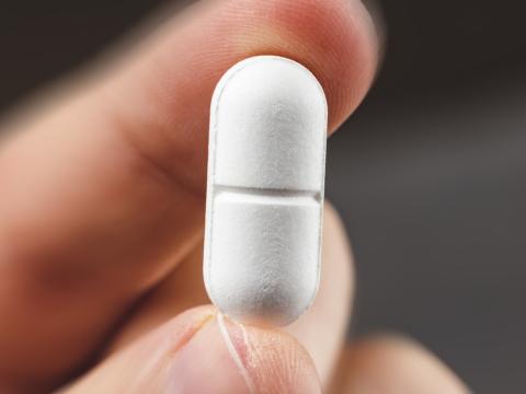 Hand holding a white tablet