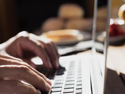 Hands typing on laptop computer