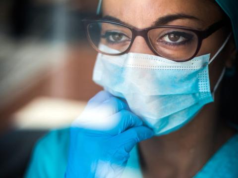 Healthcare worker wearing mask looking thoughtful