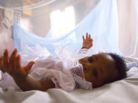 Infant under malaria bednet
