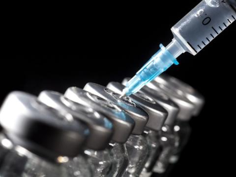 Lineaup of vaccine vials with syringe