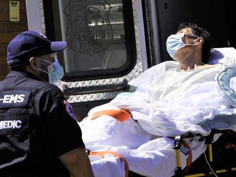 Loading a COVID-19 patient onto an ambulance