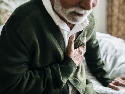 Man having heart attack holding chest